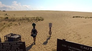 Person wearing Google's camera backpack walks on beach