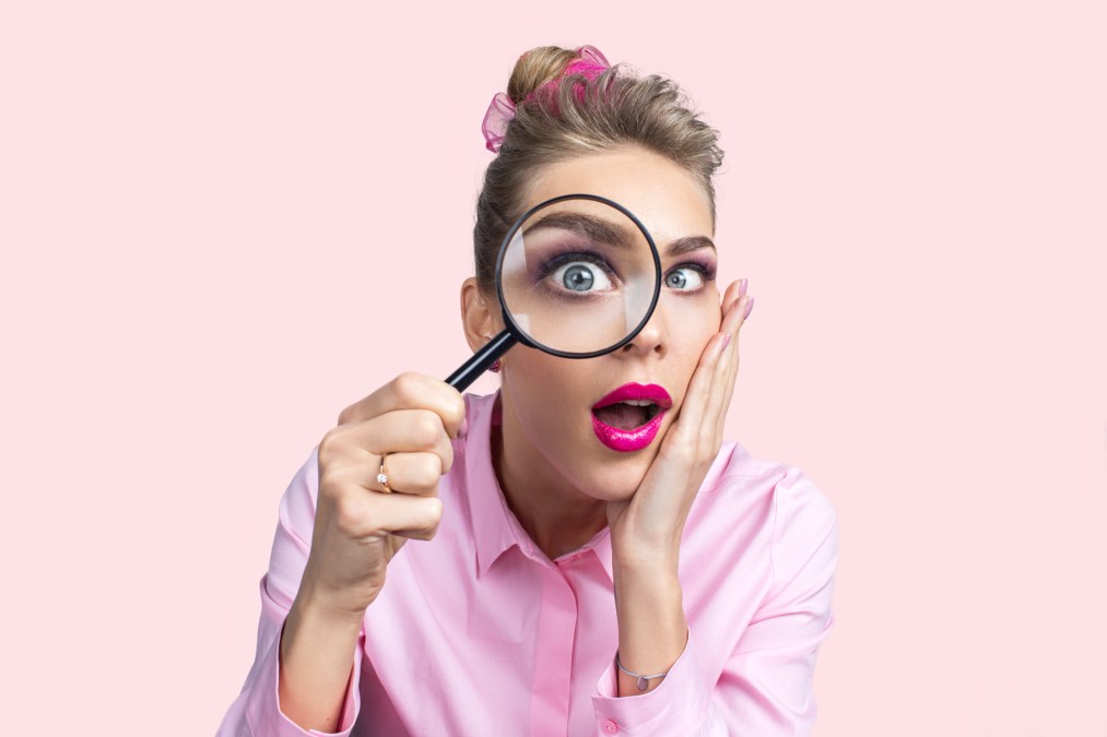 woman in pink with magnifying glass