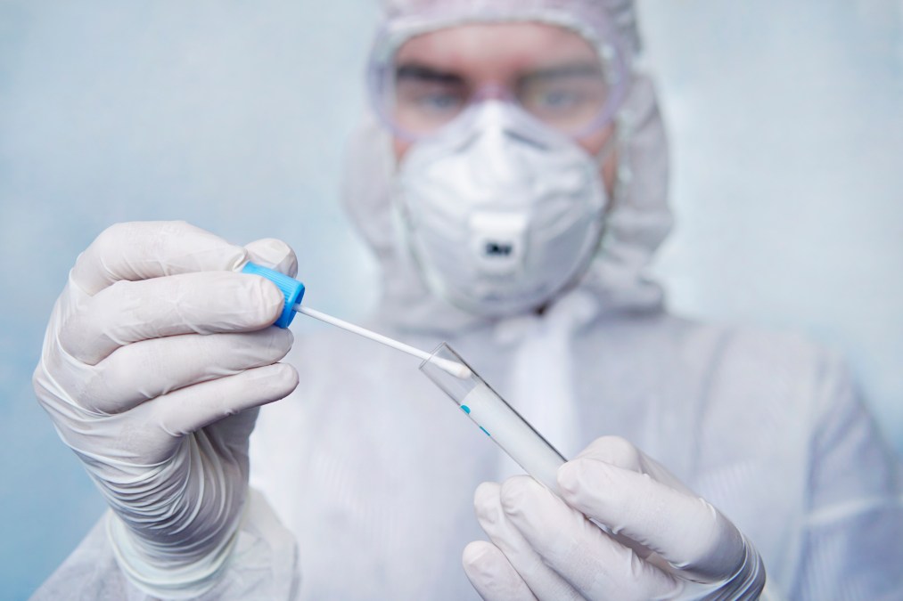 guy in biomedical gear holding swab