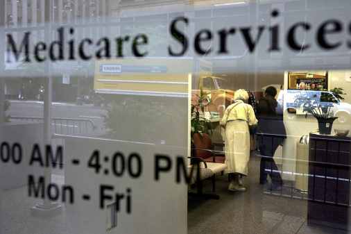 Two people walk inside a Medicare Services office on the last day for enrollment in the Medicare Part D program May 15, 2006 in New York City.