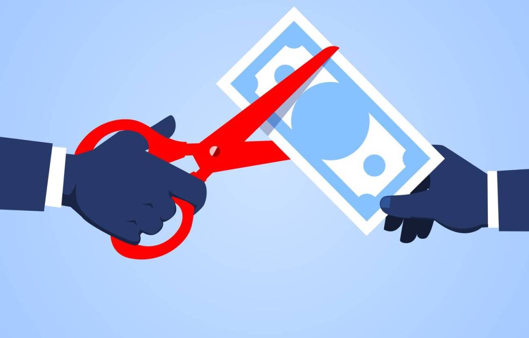 cutting dollar with red scissors